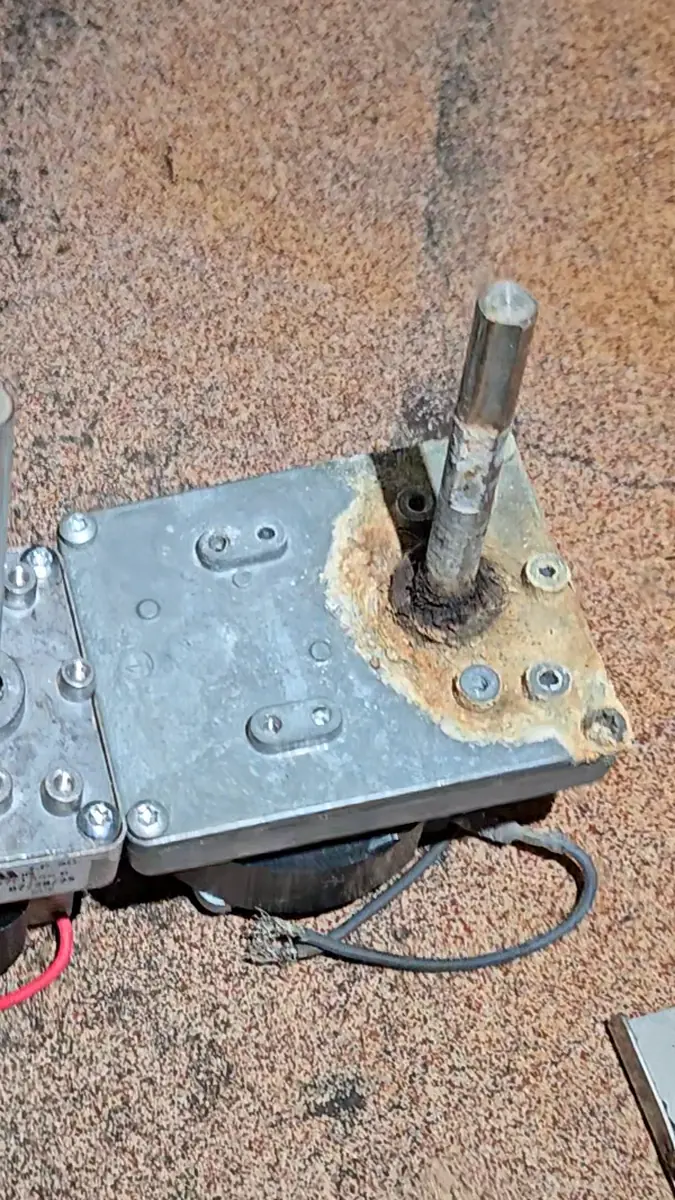 The old gearmotor with its corroded, lime-crusted output flange