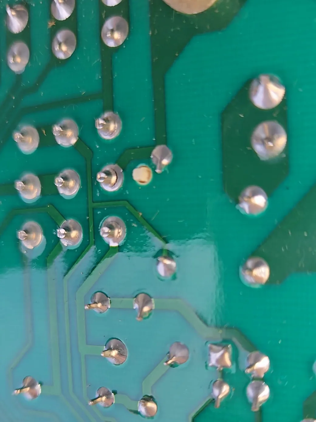Hairline ring cracks around the connector solder joints on the back of the HVAC control board.