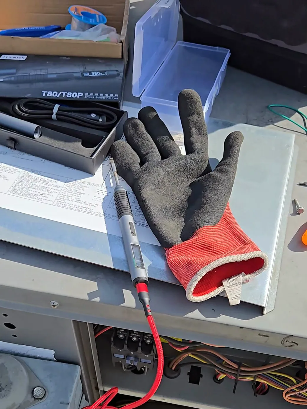 Reflowing the cracked solder joints on the control board with a soldering iron, right at the rooftop unit.
