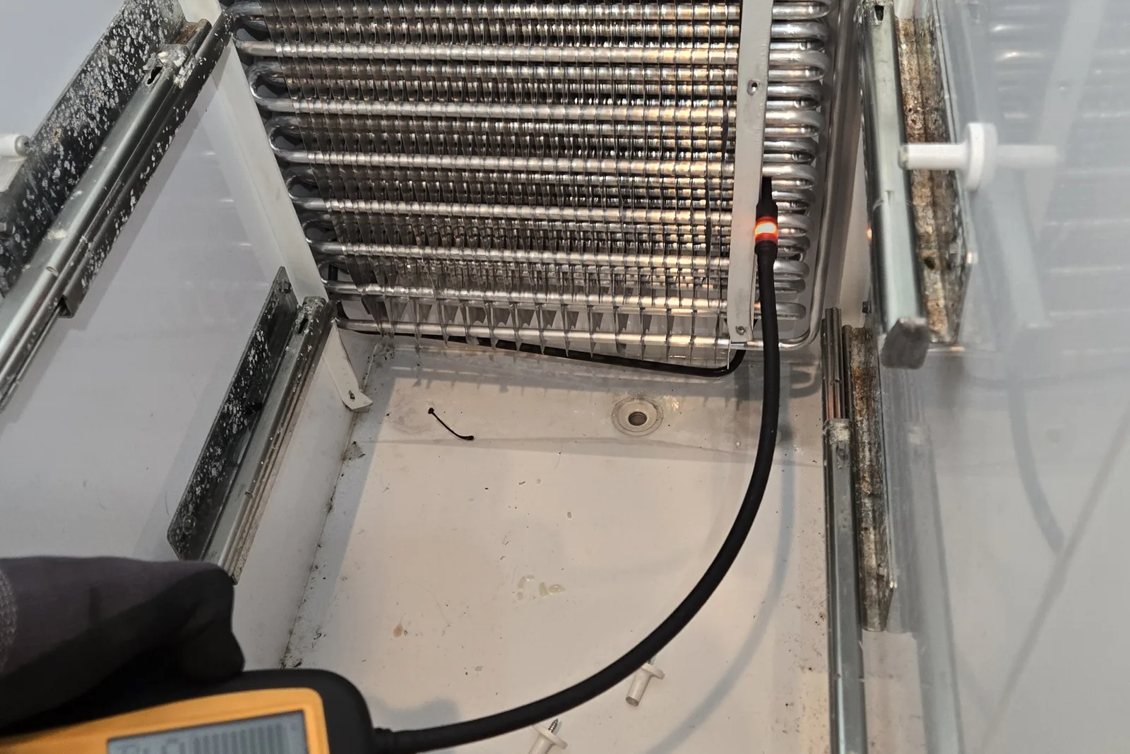 Electronic refrigerant leak detector alarming at the return bend of a KitchenAid built-in refrigerator's aluminum evaporator coil