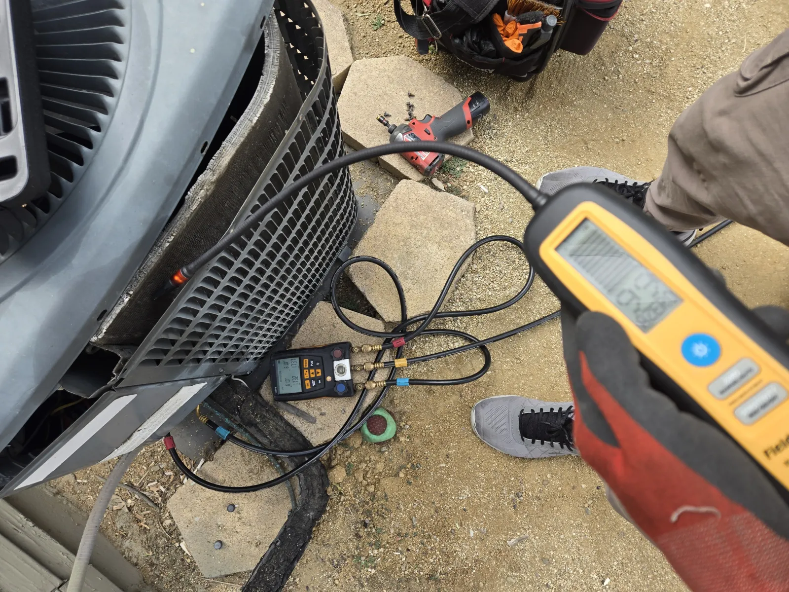 Digital manifold gauges and a Fieldpiece electronic leak detector on an old R22 condenser unit during a refrigerant leak search in Sherman Oaks.