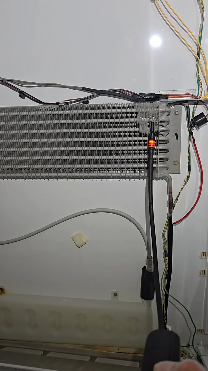 Electronic leak detector checking the evaporator coil of a built-in refrigerator