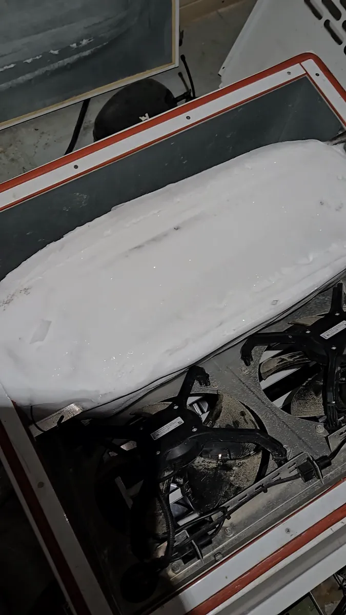 Evaporator coil of a bakery walk-in cooler frozen solid under a slab of ice in Los Angeles