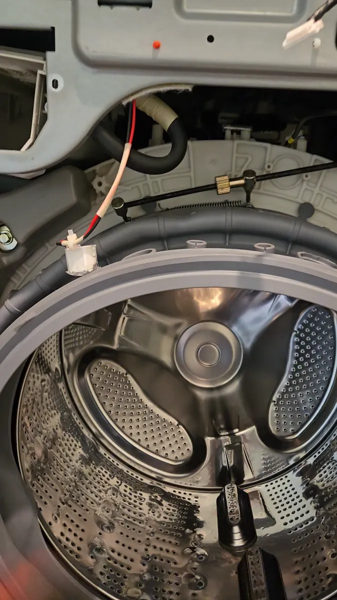 Inner spring of the washer door boot being stretched on with a hook tool