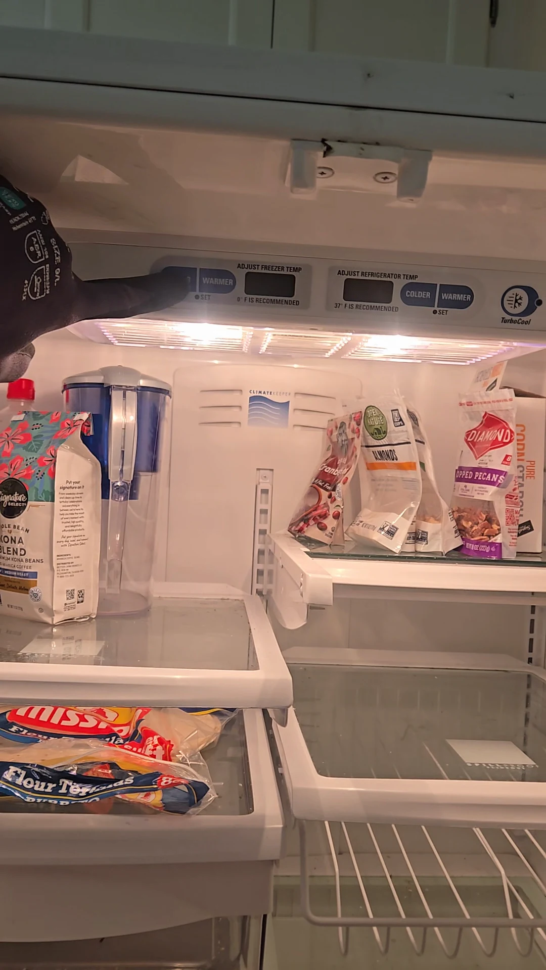 The refrigerator light is on beneath a blank temperature display.