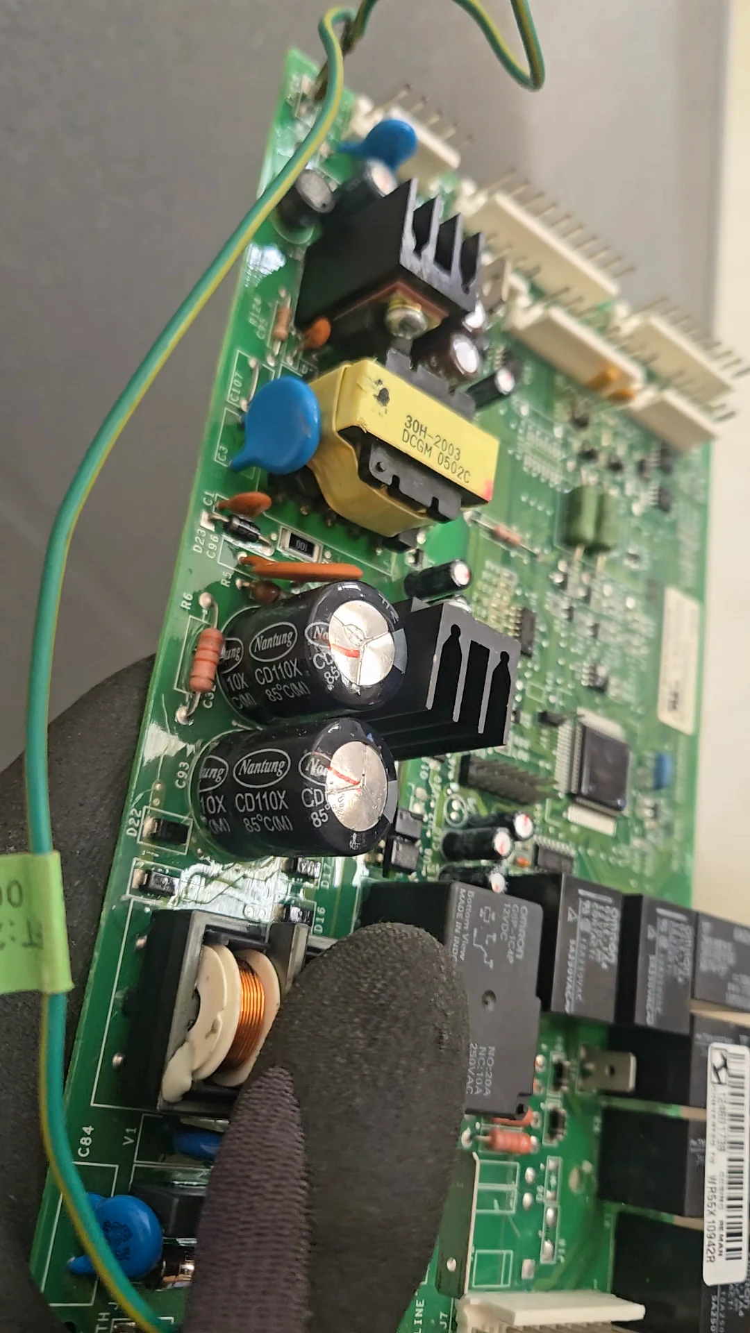 Bulging capacitor tops on the GE refrigerator control board.