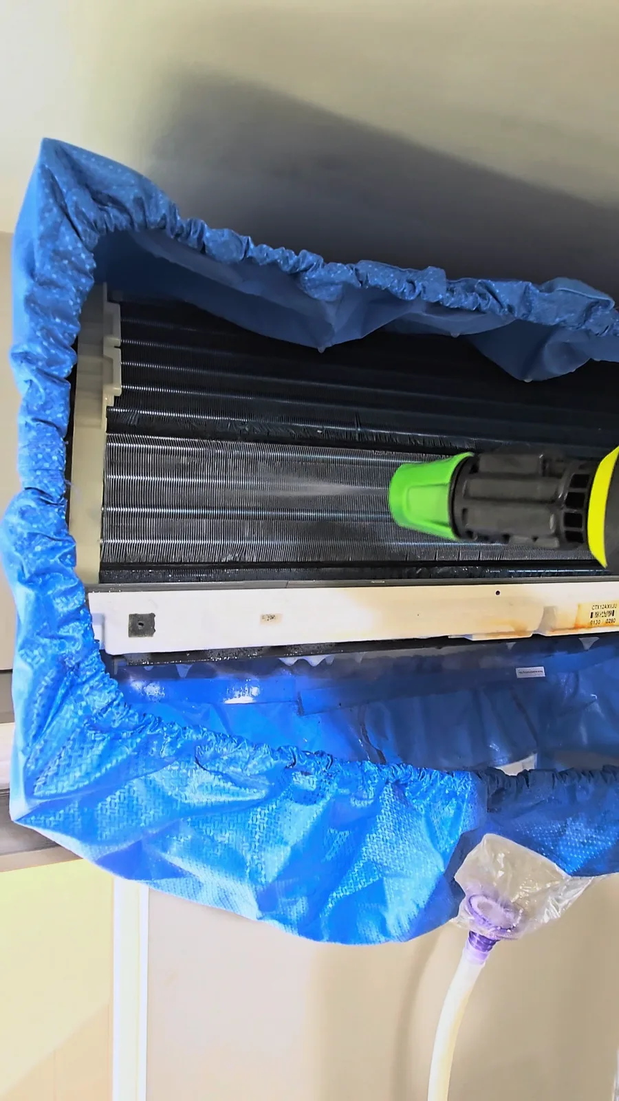 Rinsing the foam off the mini-split coil with a sprayer