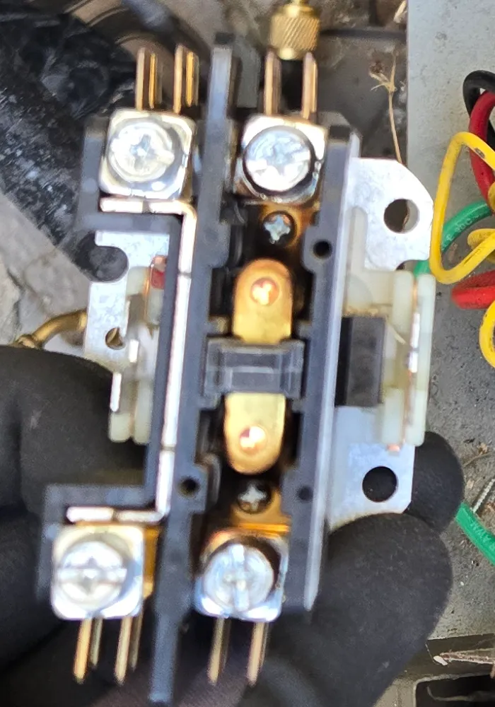 Close-up of the York condenser contactor, with scorch marks around the contacts in its center window
