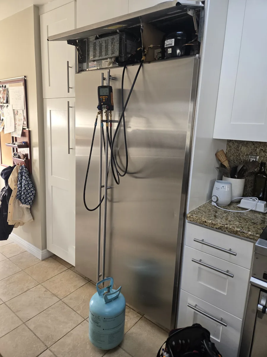 GE Monogram built-in column refrigerator with top panel open and digital manifold gauges connected by Epic Star in a Bel Air kitchen