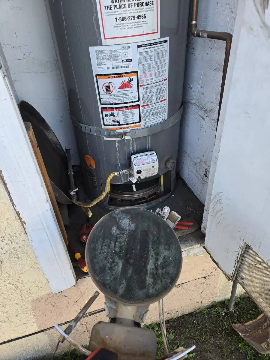 Gas water heater in an outdoor closet with its burner assembly pulled out, during a sensor repair in Sherman Oaks, CA