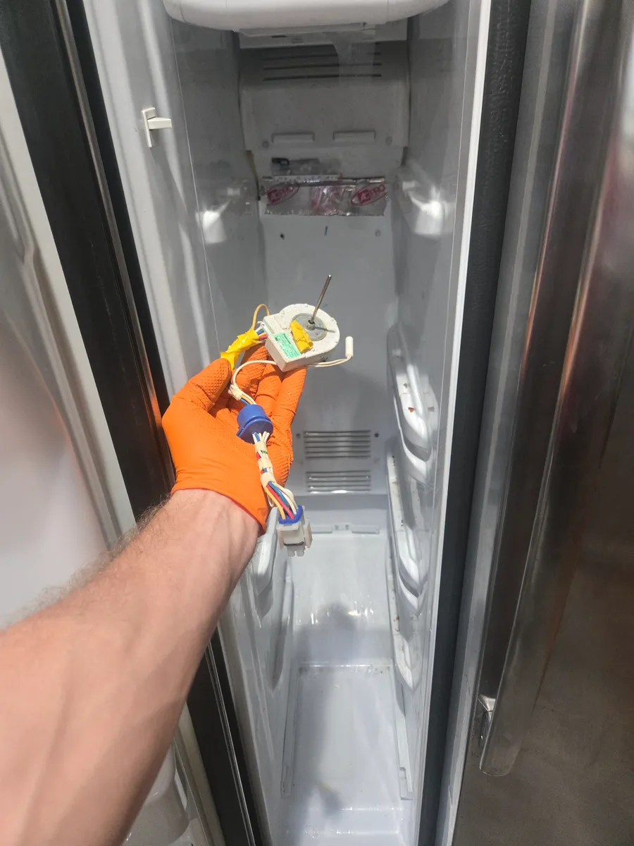 The evaporator fan motor and its harness held up inside the emptied freezer of the Whirlpool side-by-side